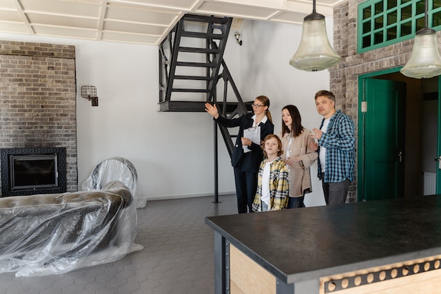 Real estate agent showing a mostly empty property to a couple and their child